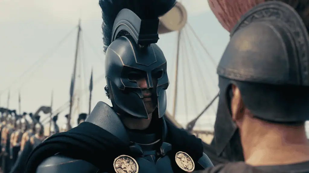 A warrior in dark, futuristic armor and helmet speaks to a fellow soldier on a battlefield with ships in the background.