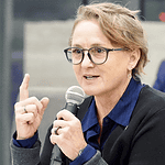Paula Lewis resigns from Oklahoma City school board after historic tenure Woman with glasses speaking into a microphone during a panel discussion in a conference setting.