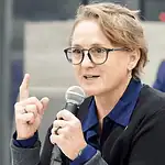 Paula Lewis resigns from Oklahoma City school board after historic tenure Woman with glasses speaking into a microphone during a panel discussion in a conference setting.