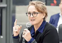 Paula Lewis resigns from Oklahoma City school board after historic tenure Woman with glasses speaking into a microphone during a panel discussion in a conference setting.