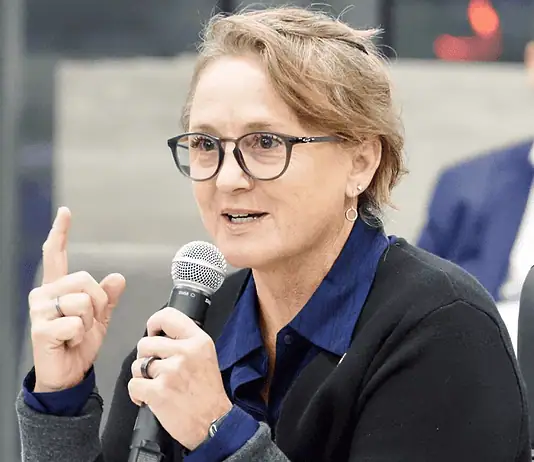 Paula Lewis resigns from Oklahoma City school board after historic tenure Woman with glasses speaking into a microphone during a panel discussion in a conference setting.