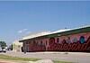 PRESS RELEASE: Residents invited to help shape the future of the Classen Corridor Clear blue sky over a street with a long mural spelling 'Boardwalk' along a pink-walled building.
