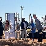 Clara Luper Civil Rights Center celebrates long-awaited groundbreaking Diverse group at a groundbreaking ceremony, each person with a shovel poised to dig on a dirt mound, banners in background.