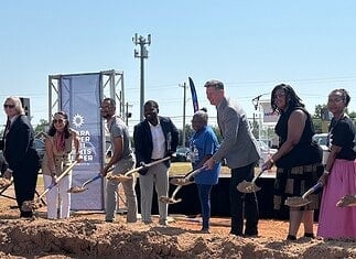 Clara Luper Civil Rights Center celebrates long-awaited groundbreaking Diverse group at a groundbreaking ceremony, each person with a shovel poised to dig on a dirt mound, banners in background.