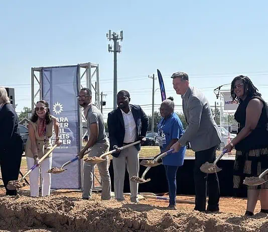 Clara Luper Civil Rights Center celebrates long-awaited groundbreaking Diverse group at a groundbreaking ceremony, each person with a shovel poised to dig on a dirt mound, banners in background.