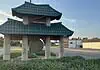Police host public discussion over homelessness, crime in Asian District Pagoda-style shelter with a teal, wavy roof over a circular 'Asian' sign on a grassy median by the road.