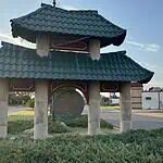 Police host public discussion over homelessness, crime in Asian District Pagoda-style shelter with a teal, wavy roof over a circular 'Asian' sign on a grassy median by the road.