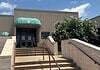 City forced to euthanize 250 birds seized in June drug bust Entrance to a beige building with green curved awnings, concrete stairs, and metal railings under a blue sky.