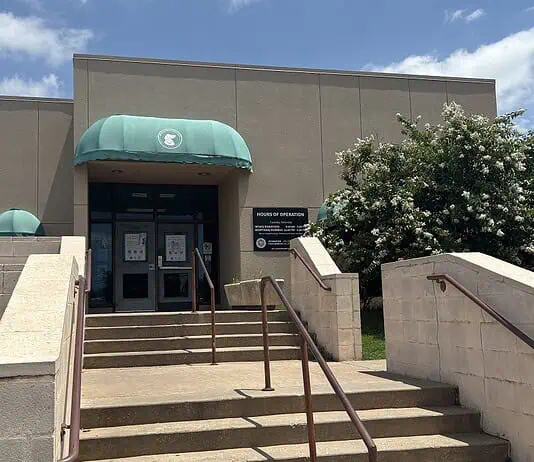 City forced to euthanize 250 birds seized in June drug bust Entrance to a beige building with green curved awnings, concrete stairs, and metal railings under a blue sky.