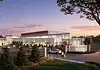 PRESS RELEASE: Final plans approved for first MAPS 4 Youth Center in Woodson Park Exterior view of the Woodson Park community center at sunset, with cars parked and people walking toward a landscaped entrance.