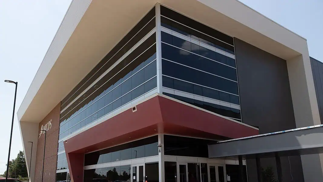 Capitol Hill High School Modern glass-fronted commercial building with a bold red entrance canopy and brick side wall.
