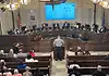City Council votes to renew contract for controversial Flock cameras Uniformed officer at the podium addressing a city council chamber full of attendees at a curved dais.