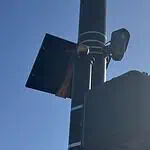 City to vote on sweeping ‘guardrails’ for Flock cameras as OKCPD continues use Streetlight pole with a solar panel, security camera, and large control box against a blue sky.