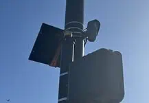 City to vote on sweeping ‘guardrails’ for Flock cameras as OKCPD continues use Streetlight pole with a solar panel, security camera, and large control box against a blue sky.
