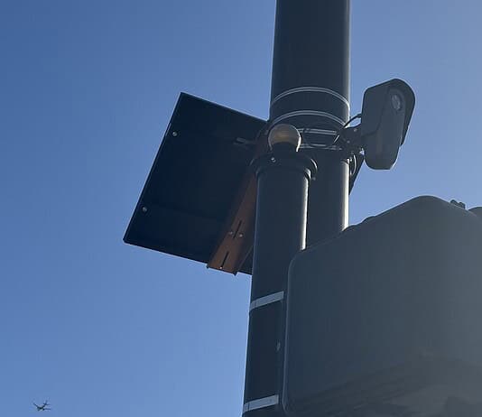 City to vote on sweeping ‘guardrails’ for Flock cameras as OKCPD continues use Streetlight pole with a solar panel, security camera, and large control box against a blue sky.